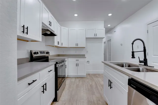 a kitchen with cabinets a sink and appliances