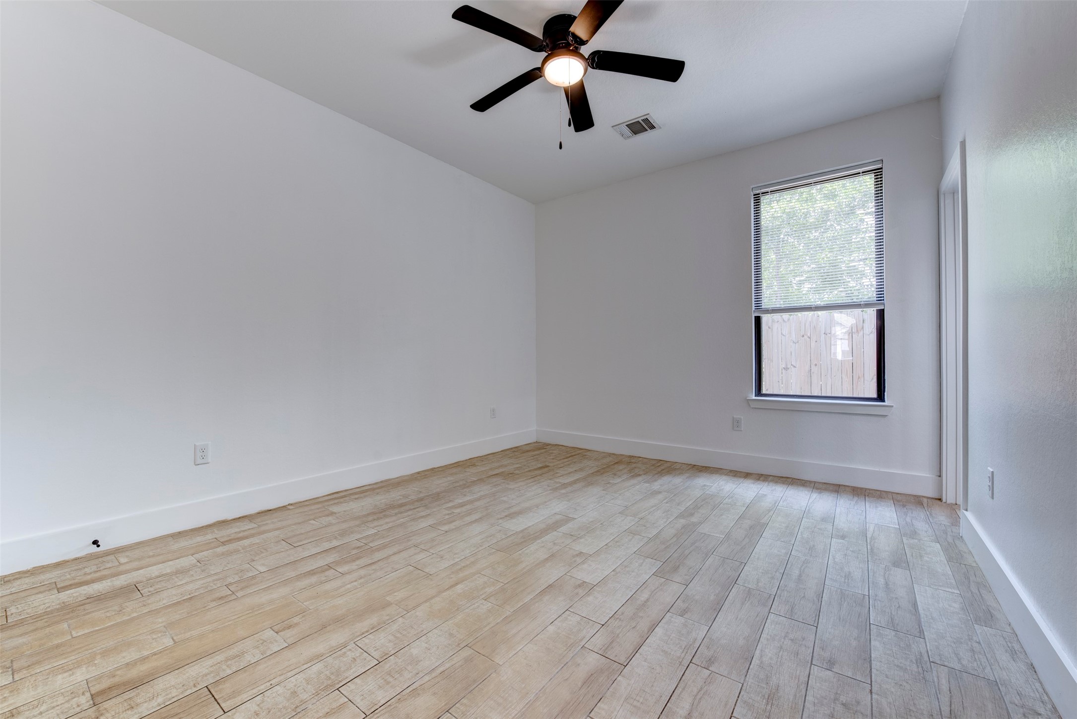 5121 Southwind Street, Unit B Houston, TX 77033 - Photo 21 of 24 a view of empty room with wooden floor and fan