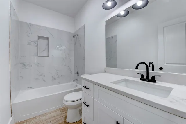 a bathroom with a sink a toilet and shower