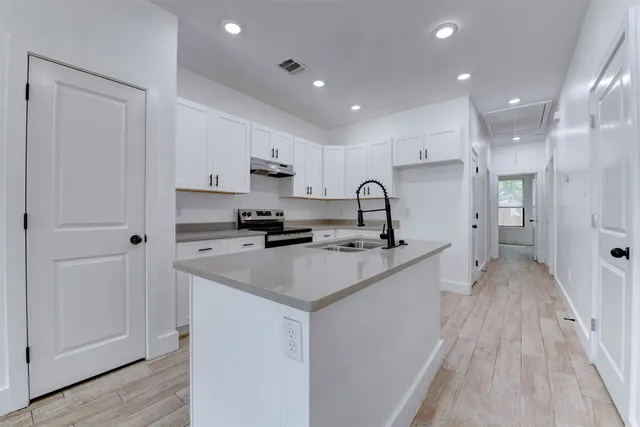 a kitchen with stainless steel appliances a sink stove and refrigerator