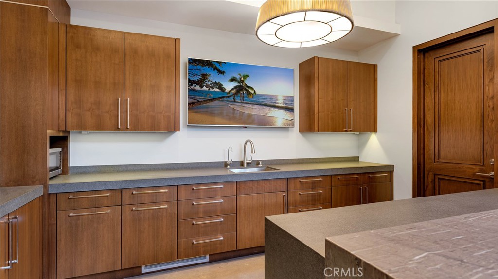 2 Thomas Road Ladera Ranch, CA 92694 - Photo 17 of 69 a kitchen with kitchen island granite countertop wooden cabinets and a sink