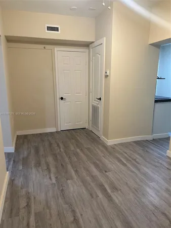 a view of an empty room with wooden floor