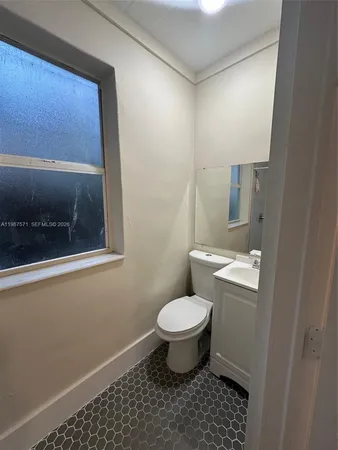 a bathroom with a toilet a sink and a mirror