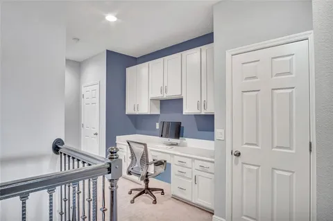 a view of a hallway with workspace and a window