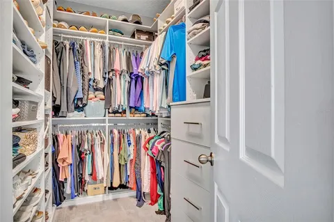 a view of walk in closet with clothes