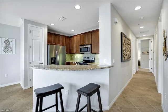 a kitchen with stainless steel appliances granite countertop a refrigerator and microwave