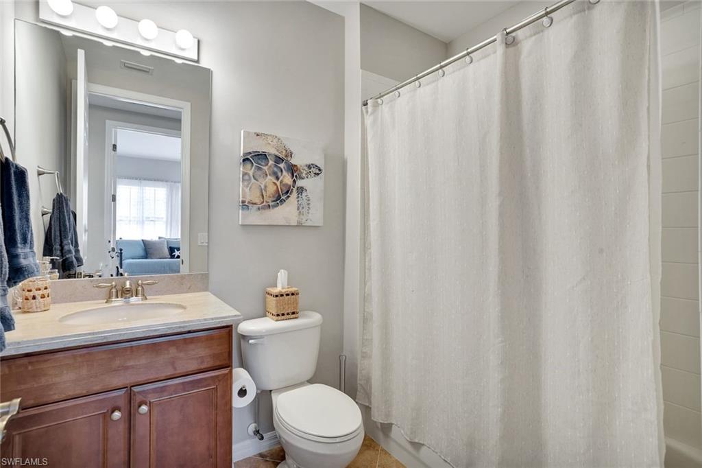 1383 Artesia Drive West, Unit 701 Naples, FL 34113 - Photo 17 of 43 a bathroom with a toilet a sink and a mirror