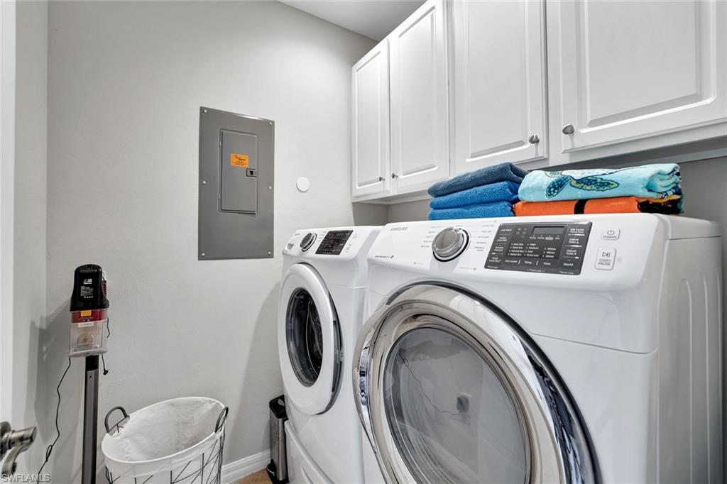 1383 Artesia Drive West, Unit 701 Naples, FL 34113 - Photo 18 of 43 a view of washer and dryer with kitchen in the background