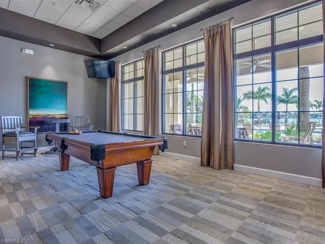a room with pool table and windows