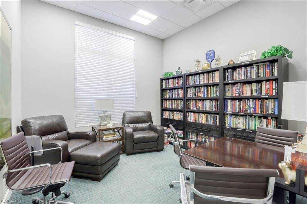 1383 Artesia Drive West, Unit 701 Naples, FL 34113 - Photo 35 of 43 a living room with furniture and a book shelf