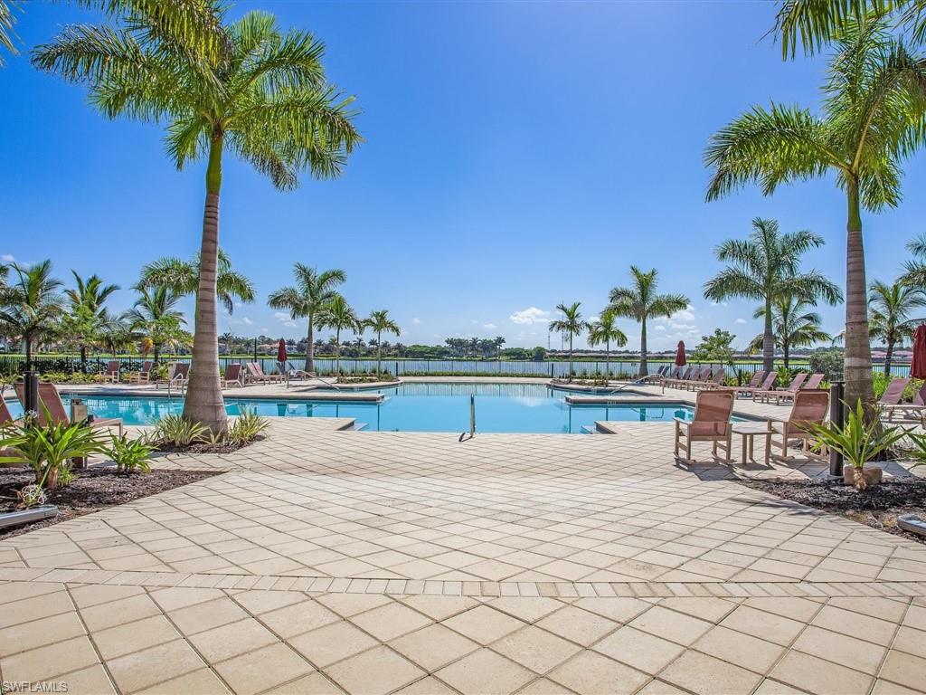1383 Artesia Drive West, Unit 701 Naples, FL 34113 - Photo 43 of 43 a view of a terrace with lawn chairs potted plants and palm trees