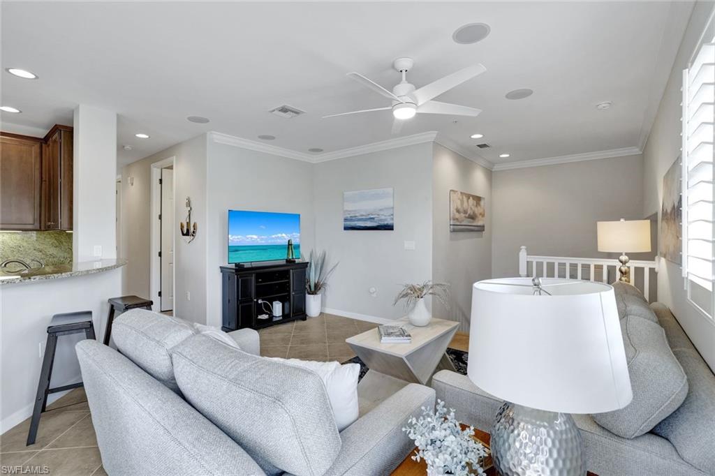 1383 Artesia Drive West, Unit 701 Naples, FL 34113 - Photo 10 of 43 a living room with furniture a fireplace and a flat screen tv