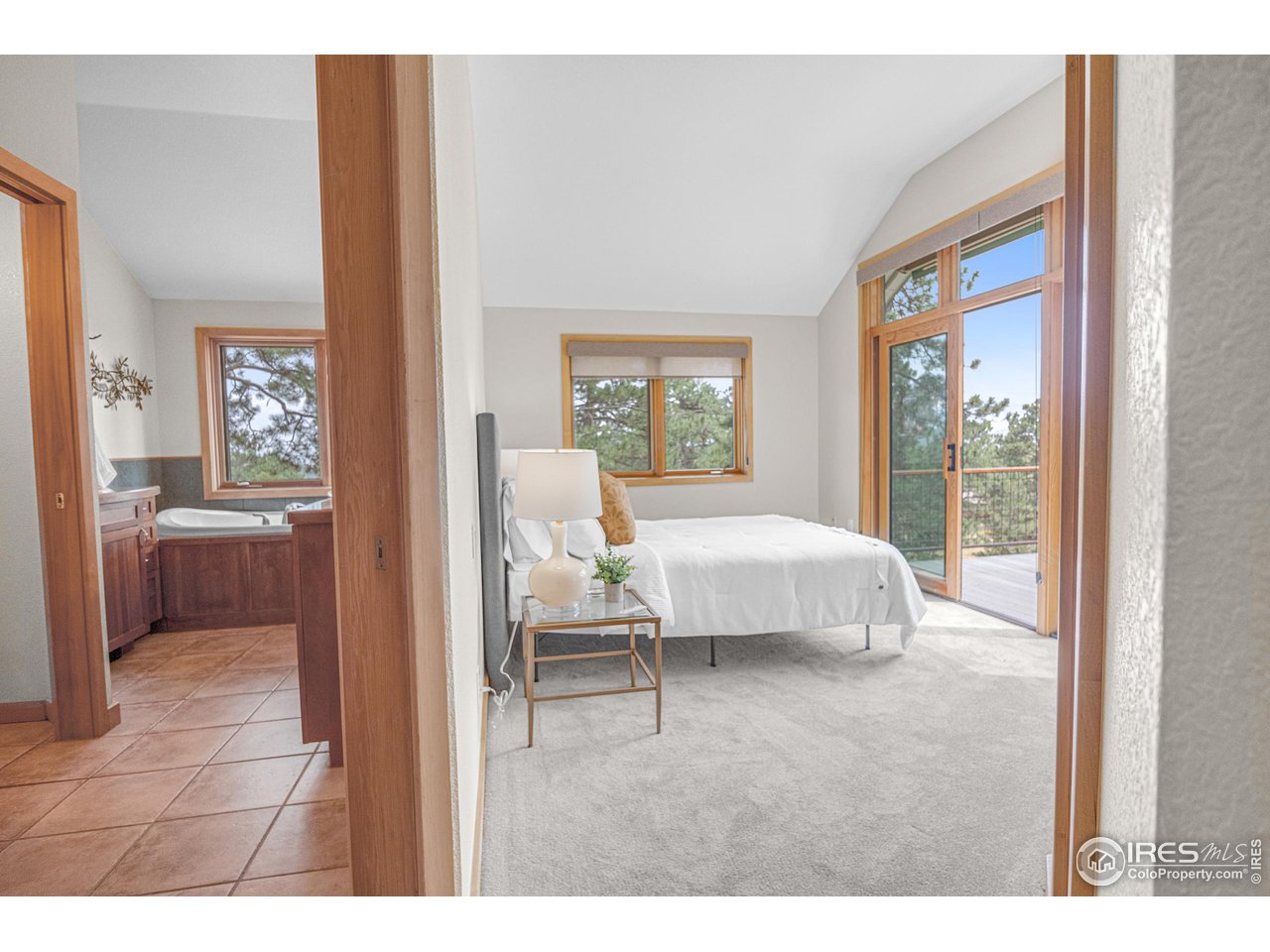 1107 Mountain Pines Road Boulder, CO 80302 - Photo 11 of 40 a bedroom with a large bed and a view of living room