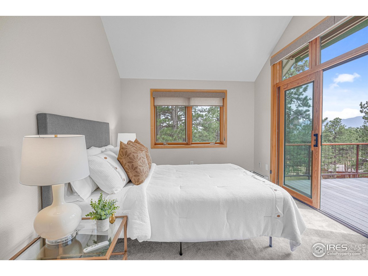1107 Mountain Pines Road Boulder, CO 80302 - Photo 30 of 40 a bedroom with a bed a lamp and a large window