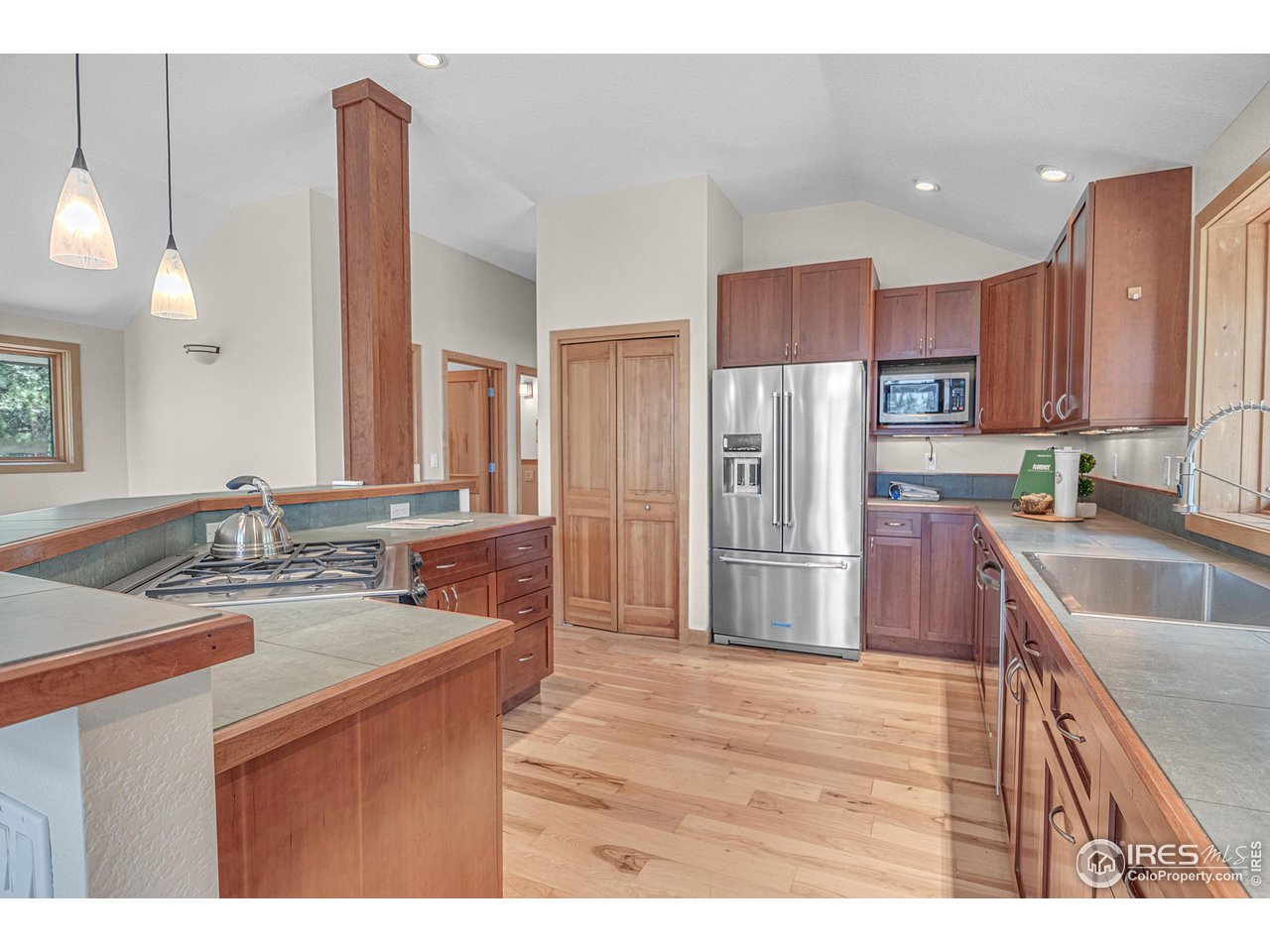 1107 Mountain Pines Road Boulder, CO 80302 - Photo 6 of 40 a kitchen with stainless steel appliances kitchen island granite countertop a refrigerator a sink a stove with wooden cabinets