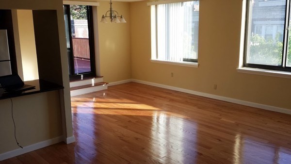 85 Brainerd Road, Unit 510 Boston, MA 02134 - Photo 6 of 25 a view of an empty room with wooden floor and a window