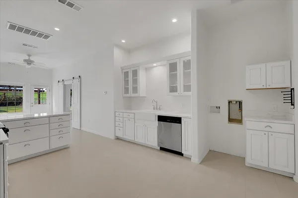 a kitchen with white cabinets and sink