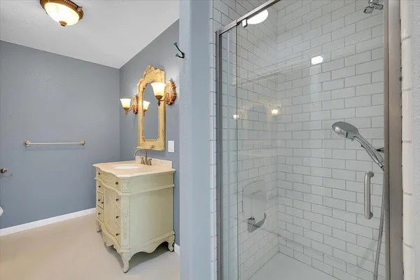a bathroom with a shower sink vanity and toilet