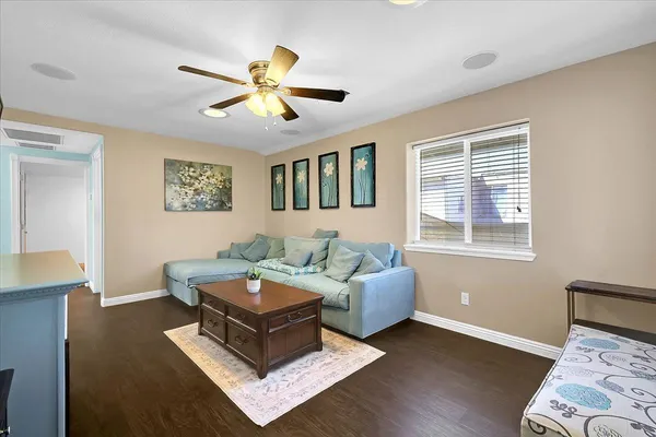 a living room with furniture and a ceiling fan