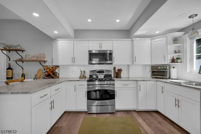 a kitchen with stainless steel appliances granite countertop a stove sink and cabinets
