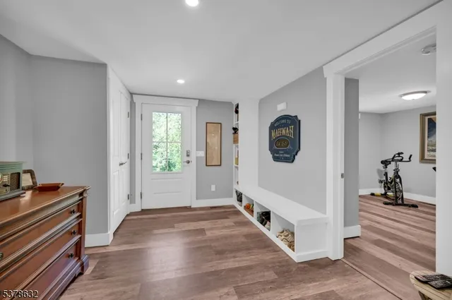 a hallway with a white cabinets and wooden floor