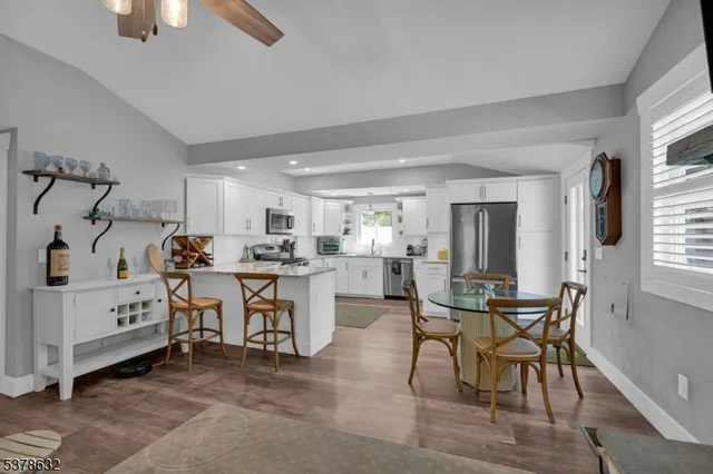 a kitchen with white cabinets and chairs