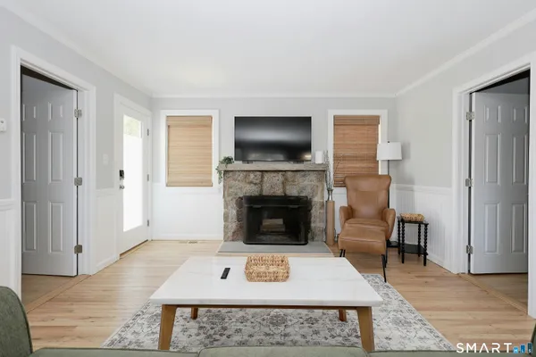 a living room with furniture a flat screen tv and a fireplace