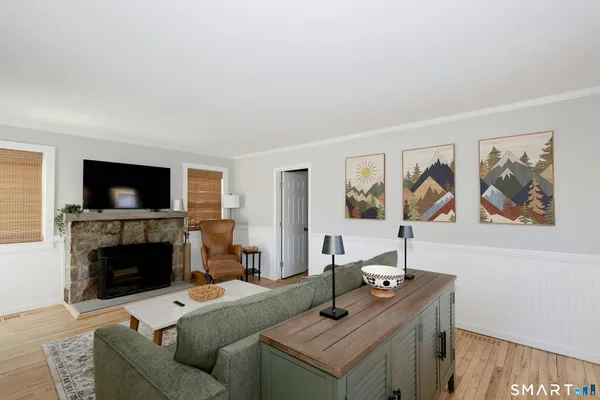 a living room with furniture a flat screen tv and a fireplace