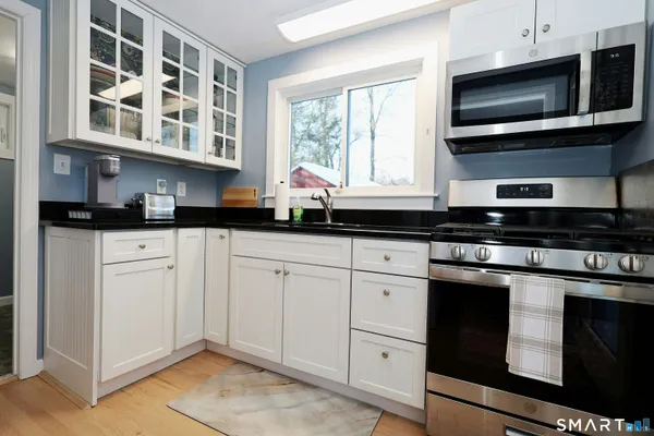 a kitchen with stainless steel appliances granite countertop a stove microwave and cabinets