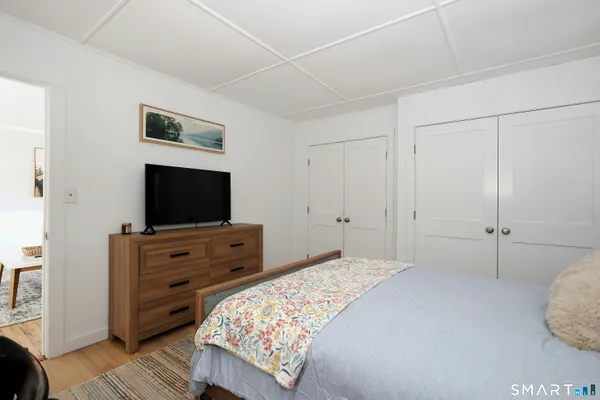 a bedroom with a bed and a flat screen tv