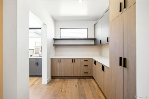 a kitchen with white cabinets and wooden floor