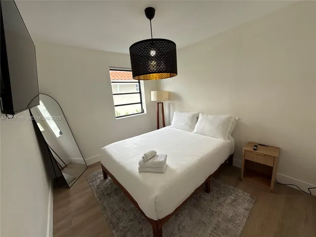 a bedroom with a bed and a flat screen tv