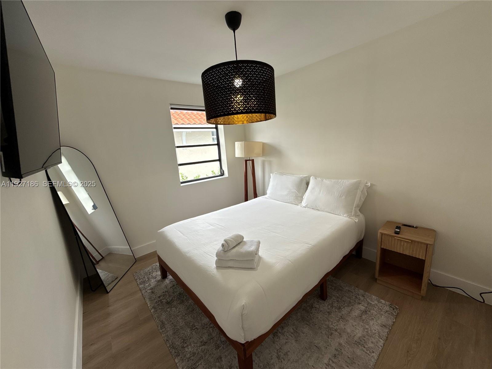 1716 Southwest 11th Street, Unit 4 Miami, FL 33135 - Photo 11 of 12 a bedroom with a bed and a flat screen tv