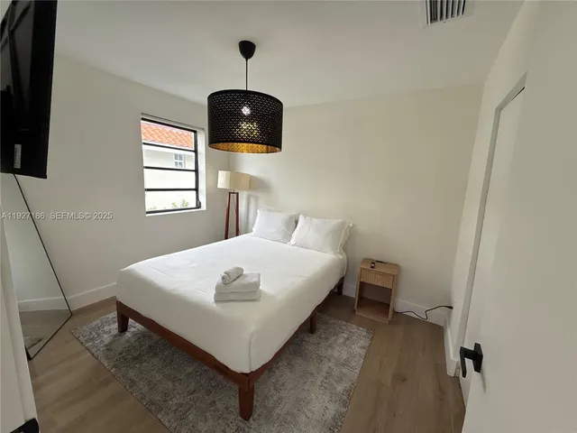 a bedroom with a bed and a flat screen tv