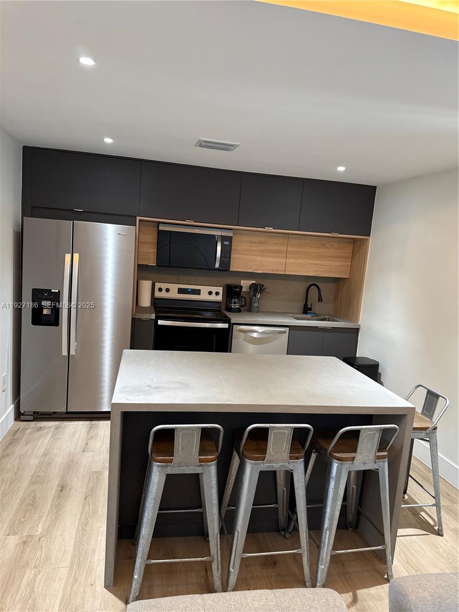 1716 Southwest 11th Street, Unit 4 Miami, FL 33135 - Photo 5 of 12 a kitchen with appliances cabinets and wooden floor