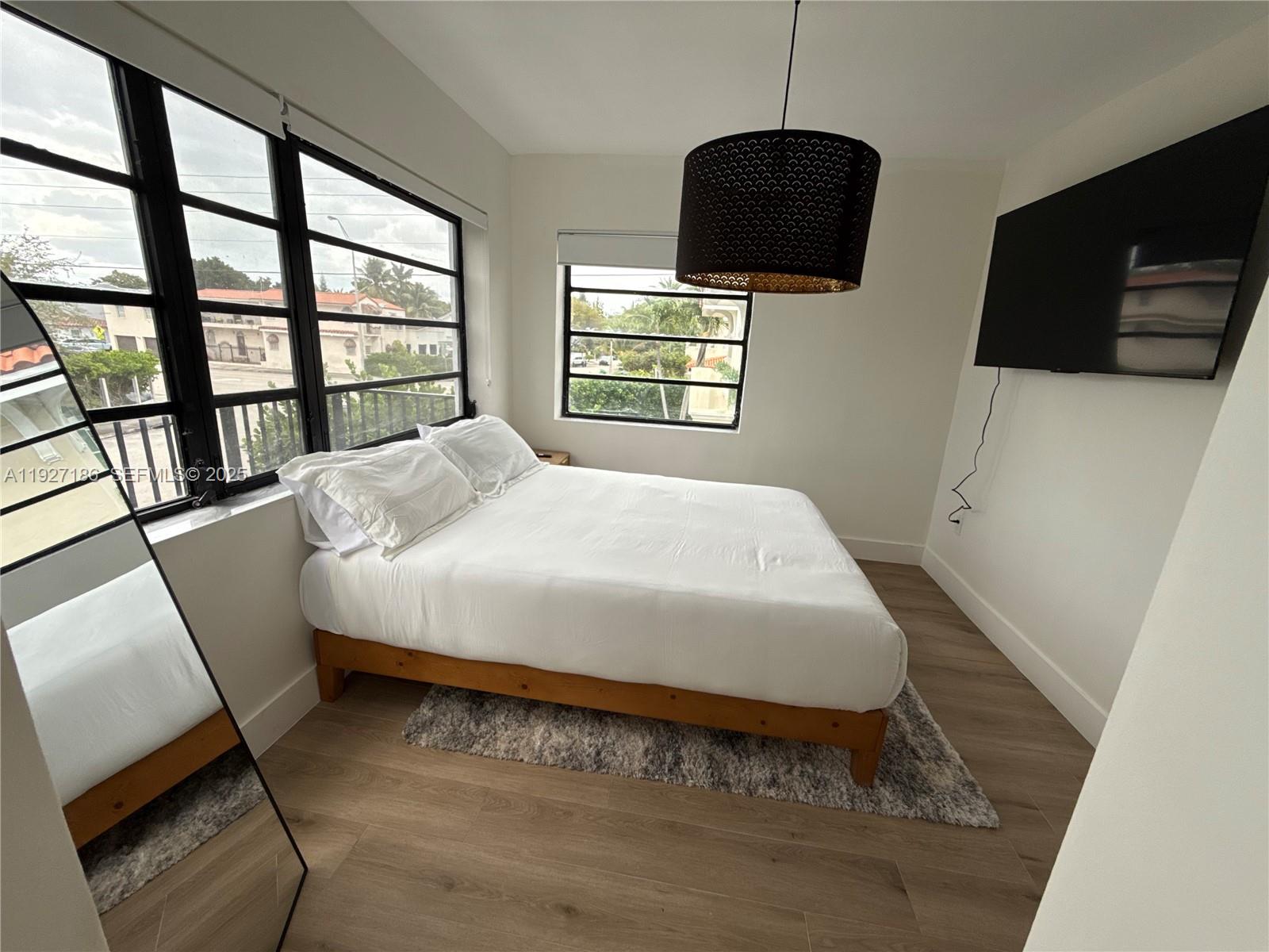 1716 Southwest 11th Street, Unit 4 Miami, FL 33135 - Photo 7 of 12 a bedroom with a bed a dresser and a flat screen tv