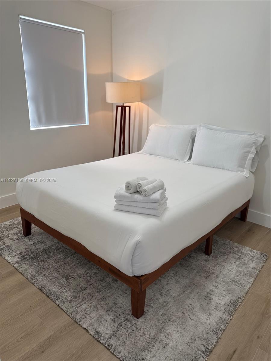 1716 Southwest 11th Street, Unit 4 Miami, FL 33135 - Photo 9 of 12 a bed sitting in a bedroom next to a lamp