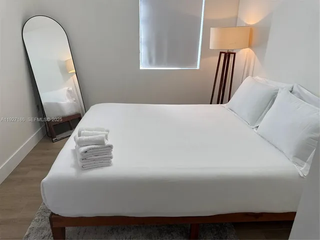 a bedroom with a bed and a mirror