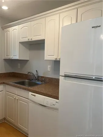 a kitchen with granite countertop a sink and a refrigerator