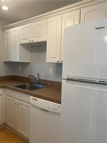 a kitchen with granite countertop a sink and a refrigerator