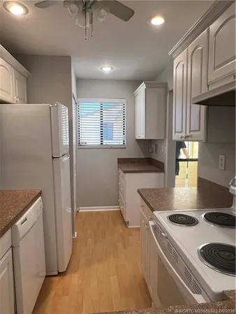 a kitchen with a white stove top oven and refrigerator