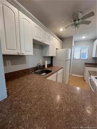 a view of kitchen with stainless steel appliances granite countertop a refrigerator a stove a sink and a cabinets