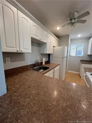 a view of kitchen with stainless steel appliances granite countertop a refrigerator a stove a sink and a cabinets