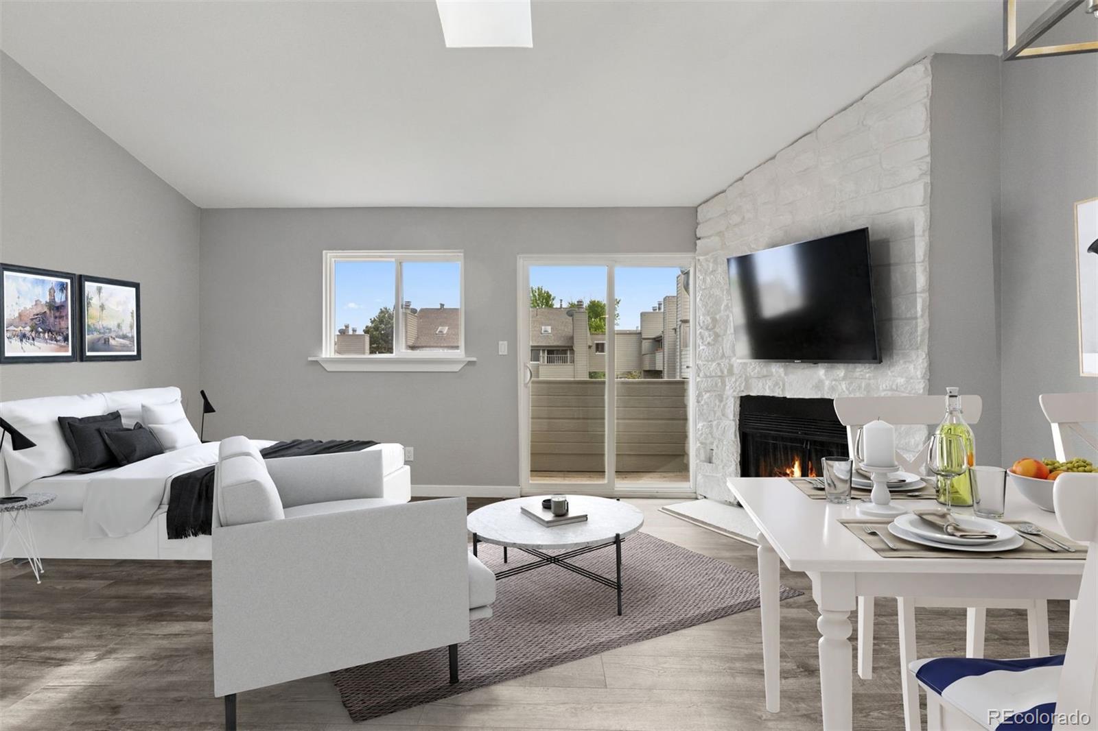3100 South Federal Boulevard, Unit 331 Denver, CO 80236 - Photo 2 of 29 a living room with furniture a fireplace and a flat screen tv