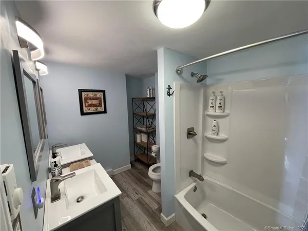 a bathroom with a bathtub shower sink vanity and toilet