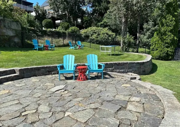 a view of a swimming pool with lawn chairs and a big yard