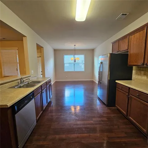 a kitchen with stainless steel appliances granite countertop a refrigerator a stove a sink and a microwave