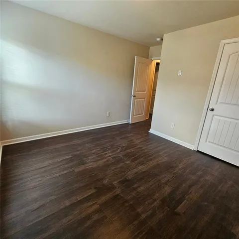 an empty room with wooden floor and entrance