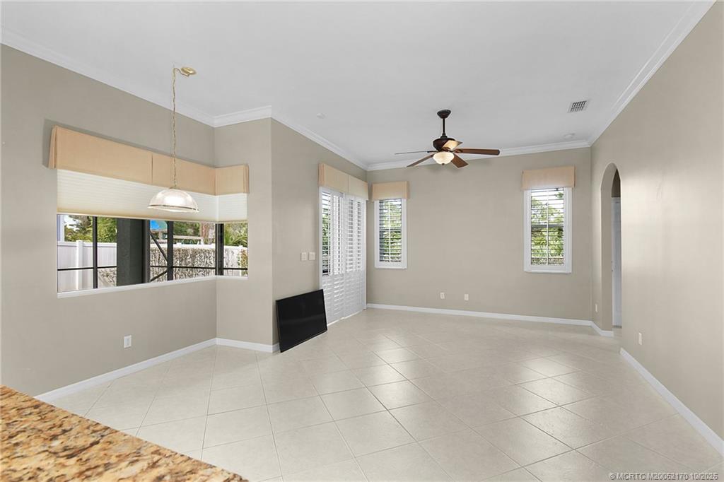 439 Northwest Sunflower Place Stuart, FL 34994 - Photo 11 of 68 a view of an empty room with wooden floor and a ceiling fan