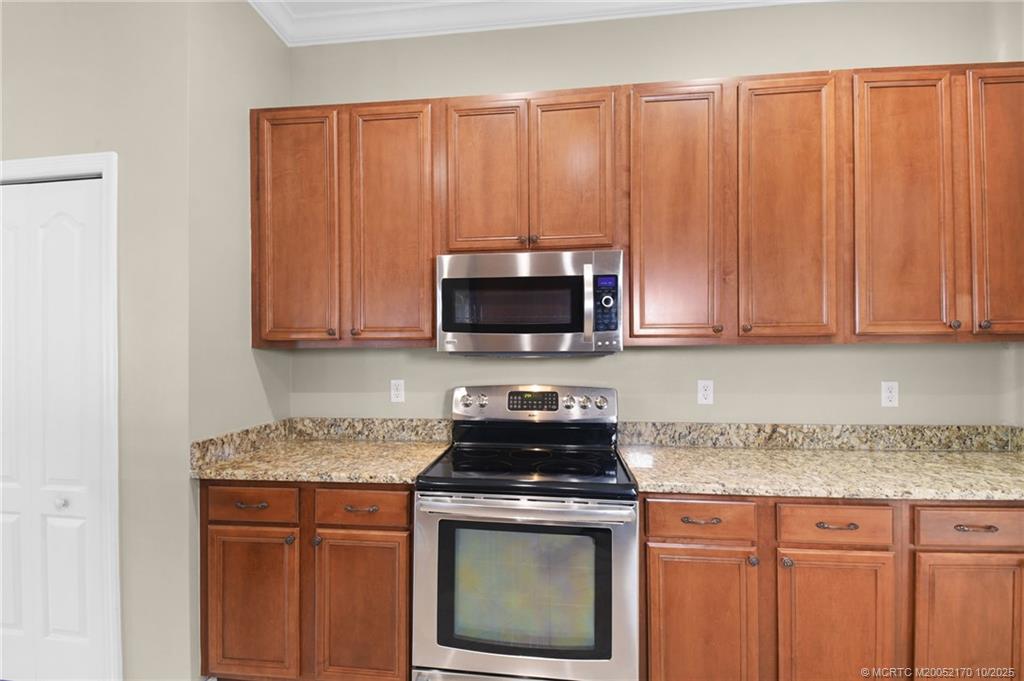 439 Northwest Sunflower Place Stuart, FL 34994 - Photo 18 of 68 a kitchen with stainless steel appliances granite countertop a stove a sink and a microwave